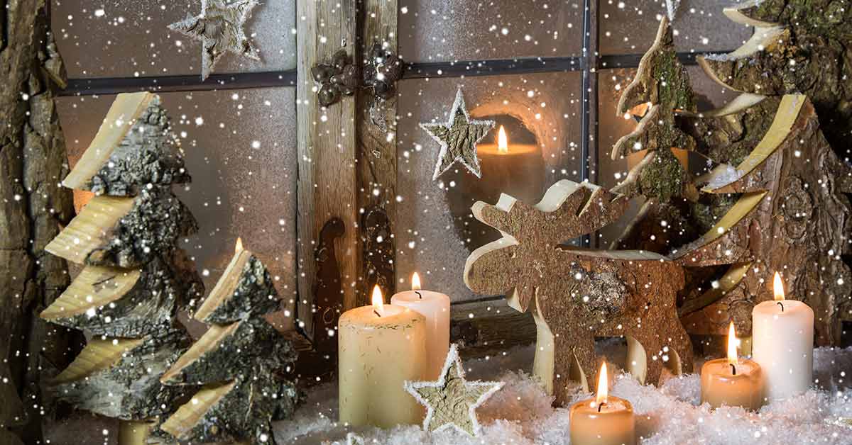 Weihnachtliches Fensterbrett mit Schnee, Kerzen, einem Elch, Sternen und Weihnachtsbäumen aus Holz